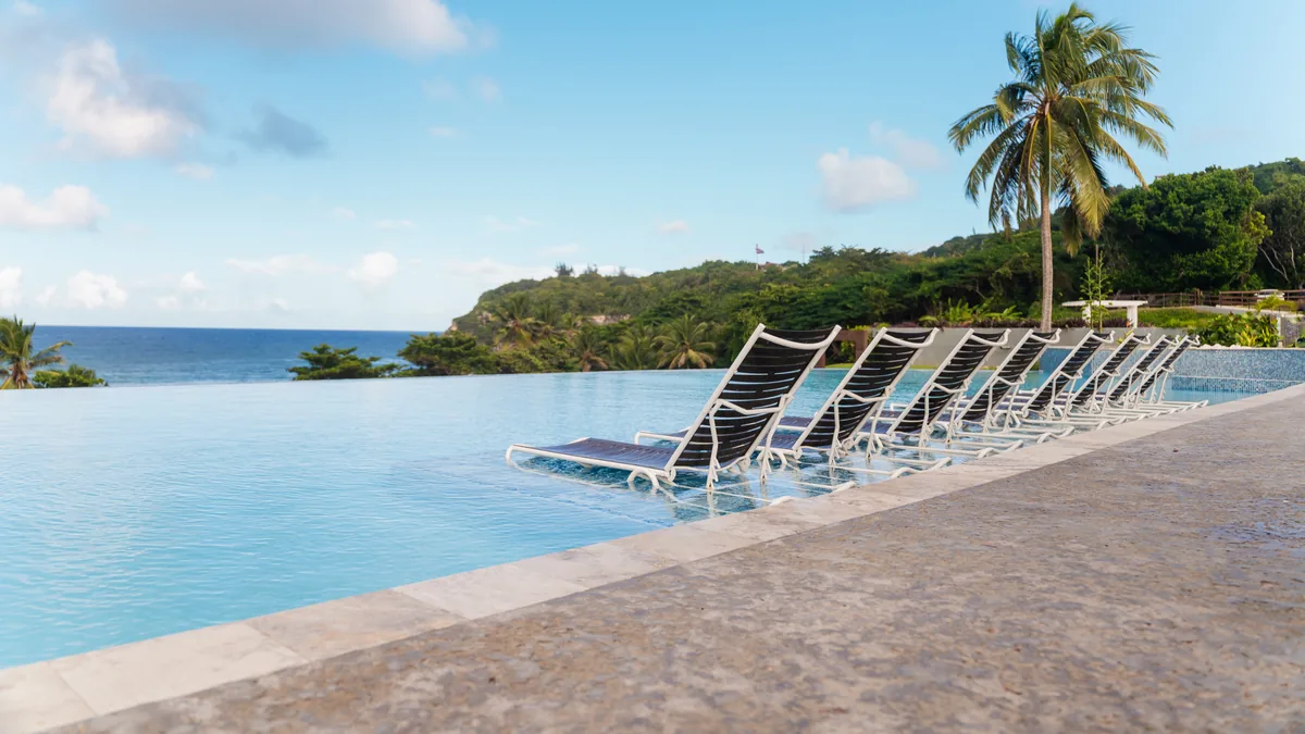 Poolside lounge chairs facing the ocean at Hotel El Guajataca.
