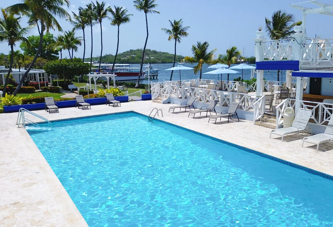 Swimming pool, loungers and palm trees beside La Parguera Bay at Parador Villa Parguera
