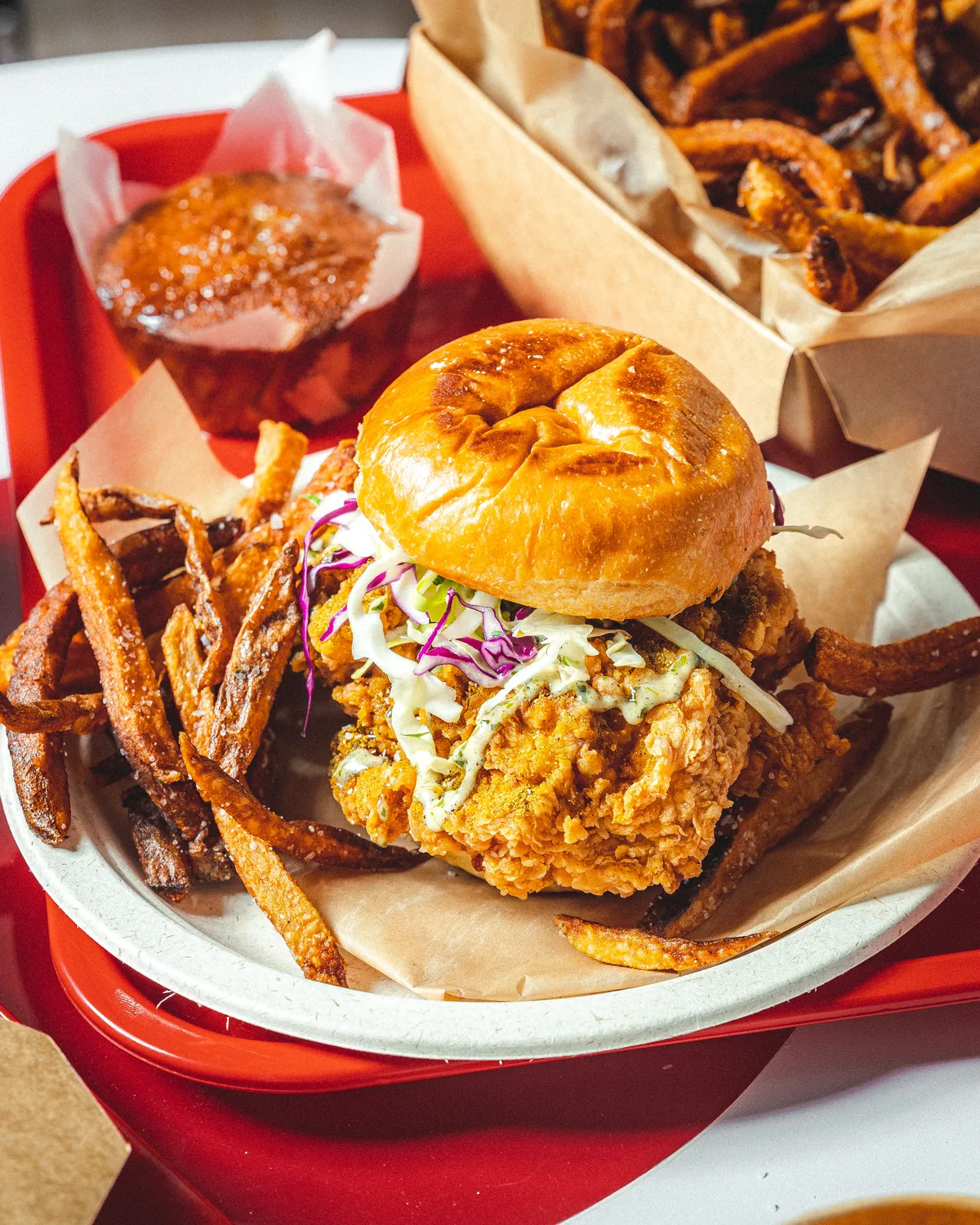 Chicken sandwich and fries served on a tray at Pollos Scharneco.